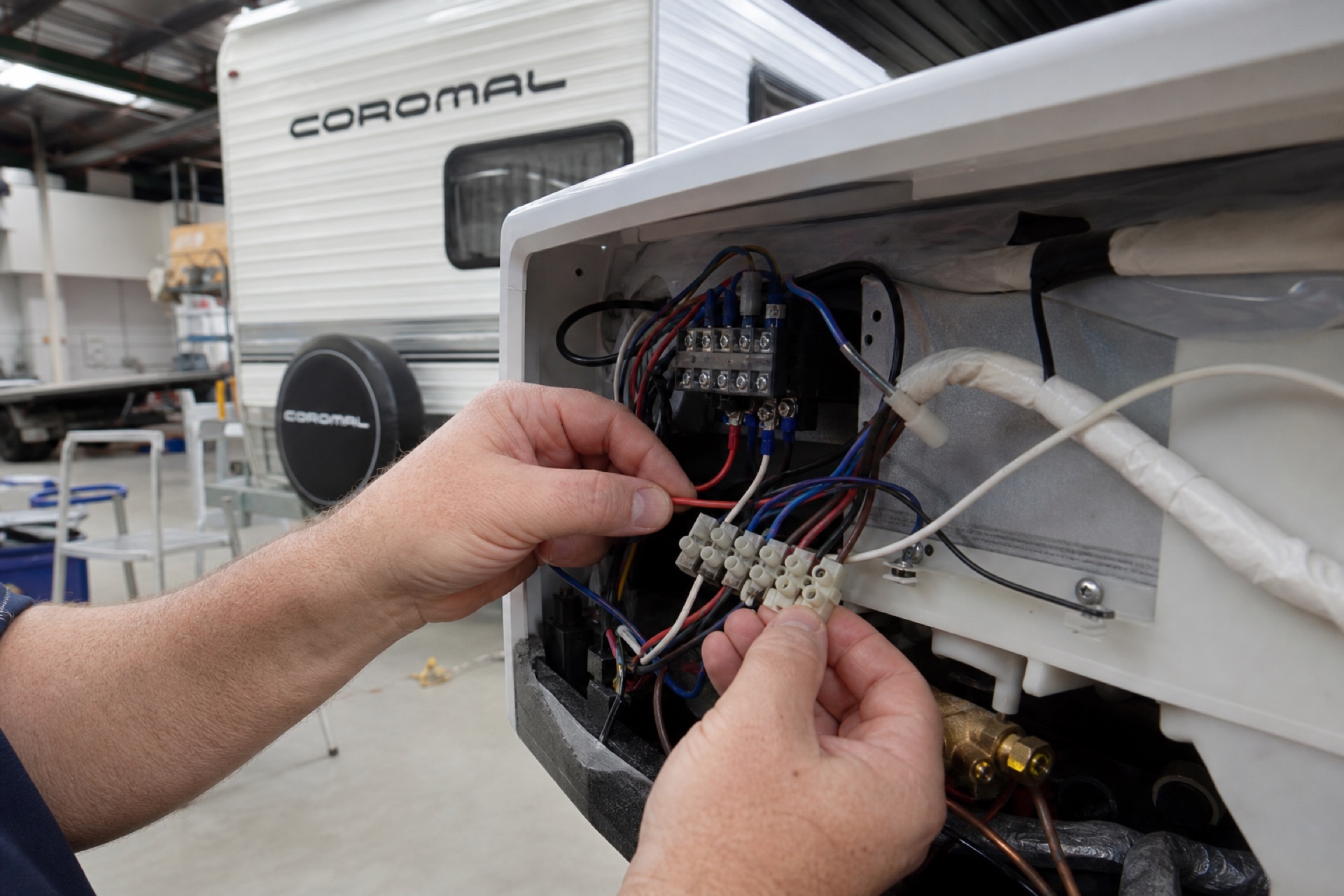 Technician hands connecting caravan air conditioner electrics