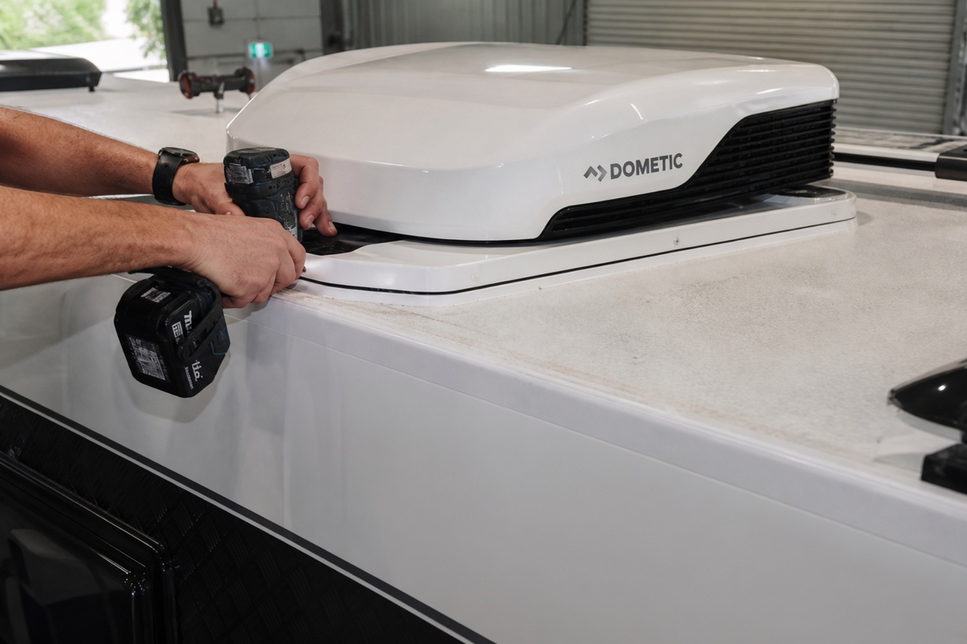 Technician hands working on caravan roof ventilation